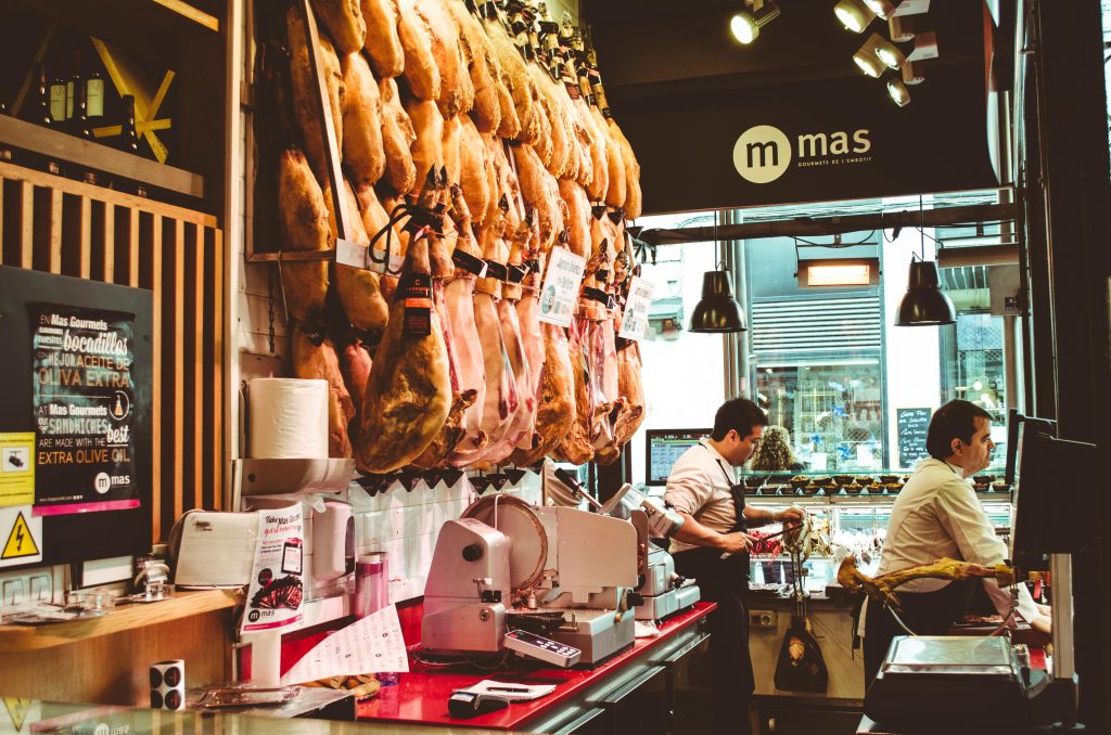 Traditional Spanish cured ham legs hanging in a local market