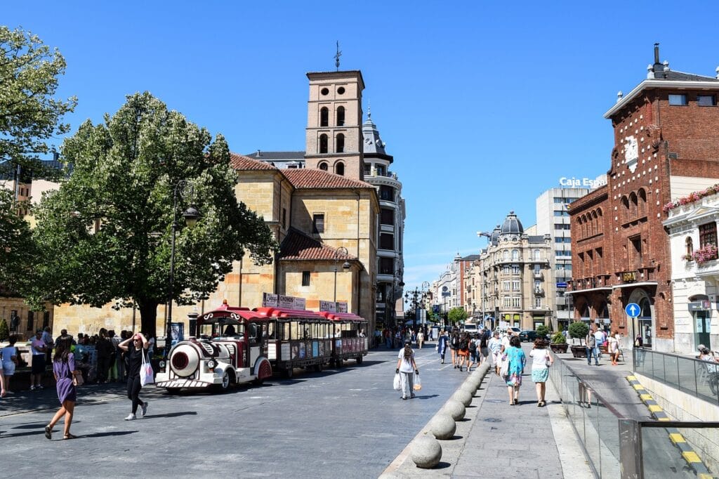 Busy street view of Calle Ancha in León with students and locals enjoying cafes and shops